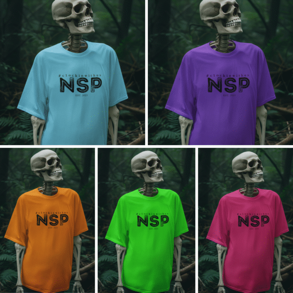 Assorted bright-colored NSP t-shirts from the Prism of the Paranormal collection, featuring the Night Shift Paranormal logo on the chest, displayed in a flat lay arrangement.